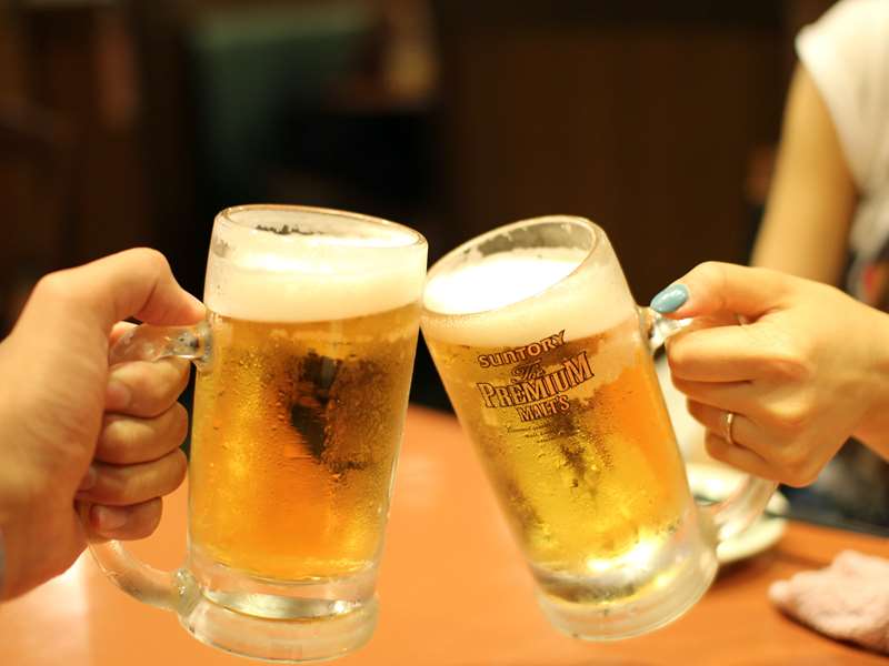 guests with pints of beer toasting 