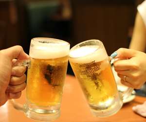 guests with pints of beer toasting 